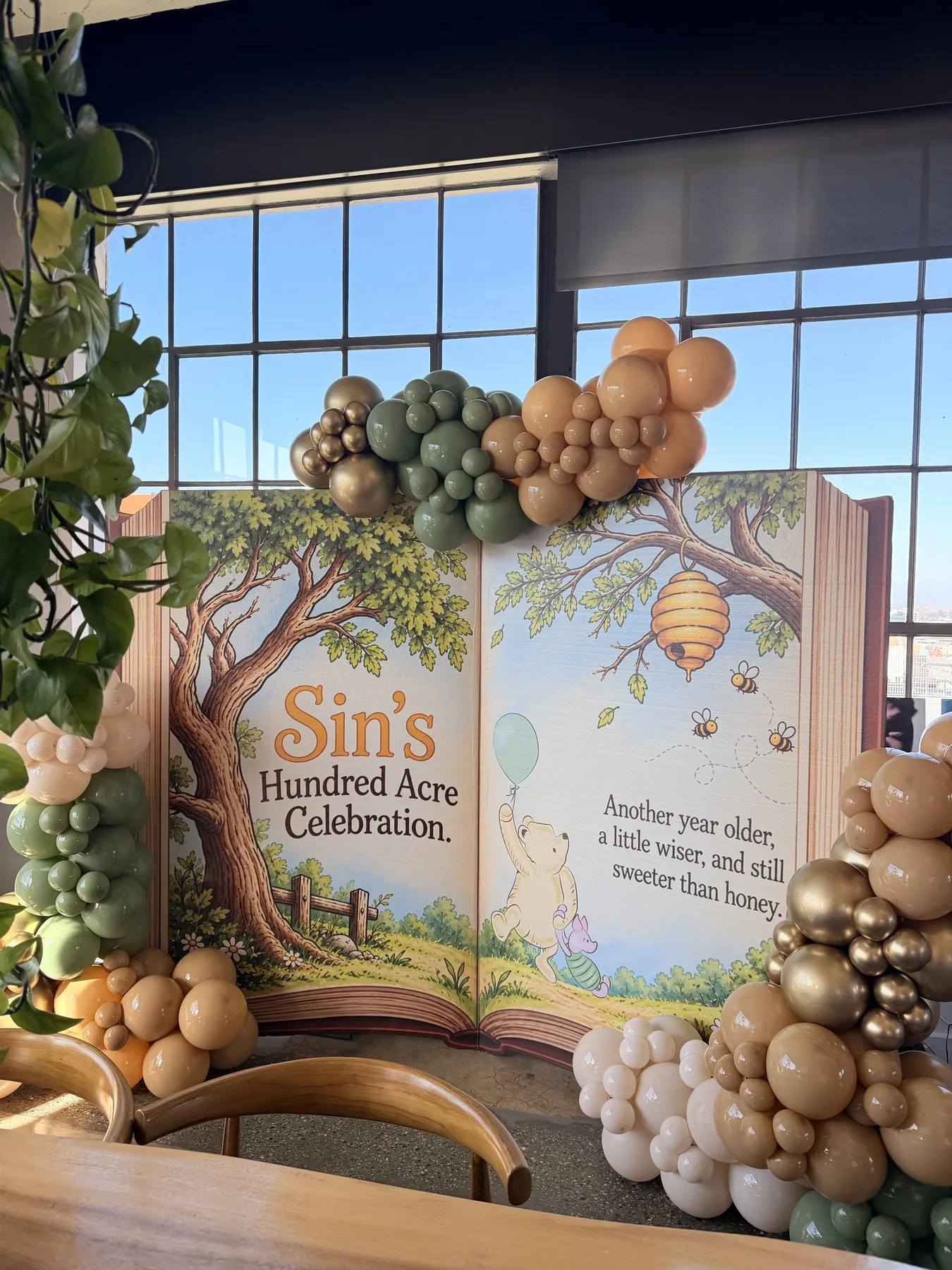 Storybook Hundred Acre Celebration backdrop with neutral balloons