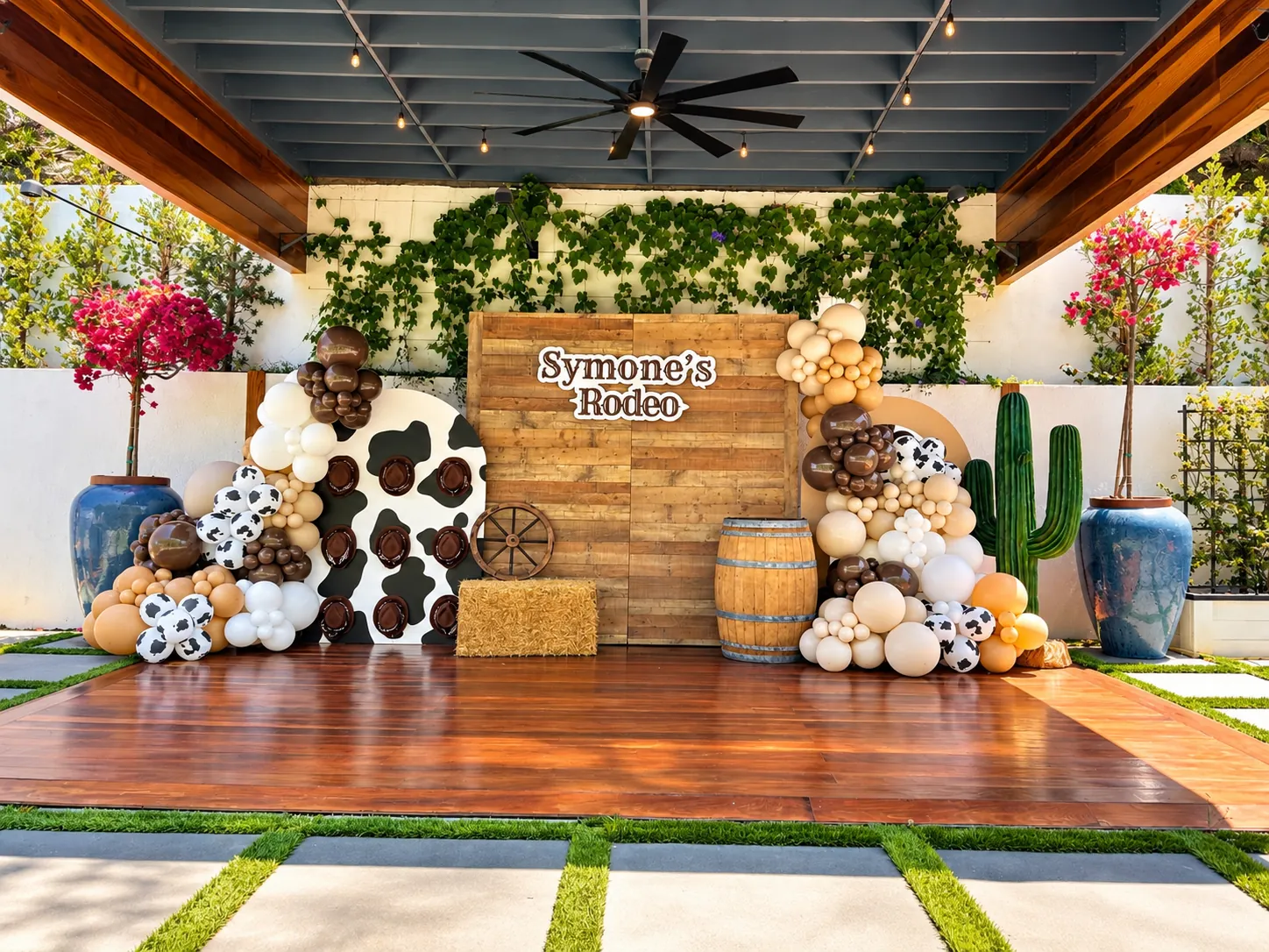Symone's Rodeo wood backdrop with cow-print balloons